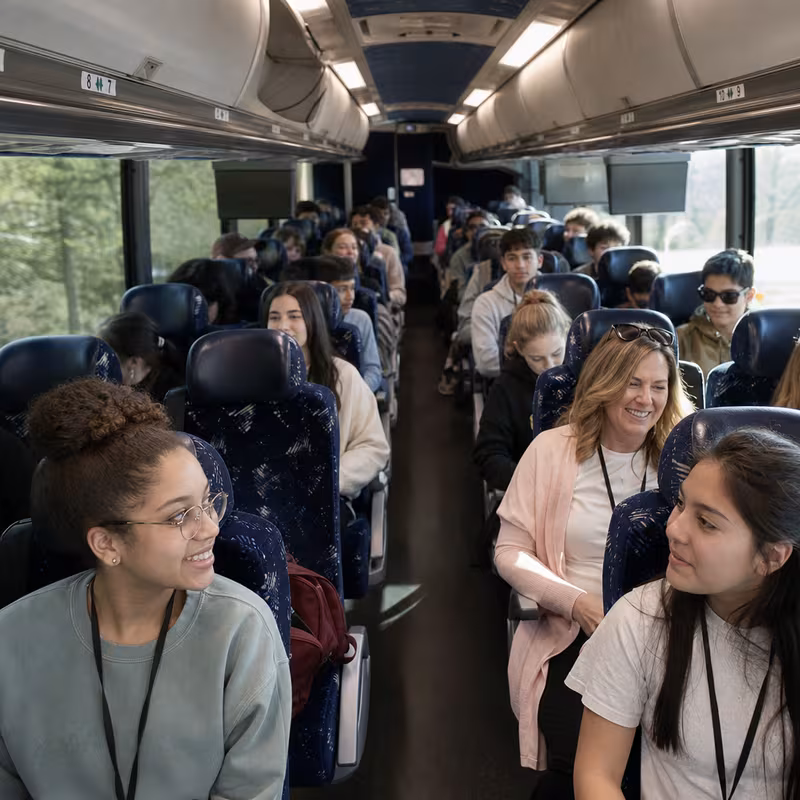Group boarding a white charter bus for School Transportation transportation in Memphis
